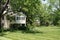 white summer house immersed in greenery with a large green lawn