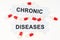 On a white surface, tablets and puzzles with the inscription - CHRONIC DISEASES