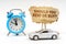 On a white surface there is a blue alarm clock, a car and a sign with the inscription - Should you rent or buy