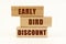 On a white surface are wooden blocks with the inscription - Early bird discount