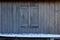 White surfboard in front of wooden shed