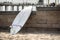 White surfboard leaning on the stone wall