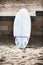 White surfboard leaning on the stone wall