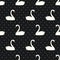 White swan seamless pattern on polka dots black background.