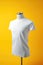 A white t-shirt on a mannequin on a yellow background