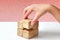 On a white table, the businesswomanâ€˜s hand arranges the last wooden block into a complete cube, Business strategy, growth