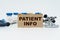 On a white table lie ampoules, a stethoscope and a cardboard with the inscription - PATIENT INFO