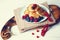 On a white table stands a wooden board with breakfast, freshly baked pancakes with fresh berries of currants, blueberries and