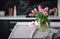 white tablecloth on black floor in kitchen with pink tulips on table