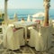 White tables and chairs in greek cafe by the sea coast, Crete, G