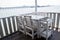 White tables and chairs in restaurant. empty rattan furniture coffee set table chair at wooden floor sea front by the sea.