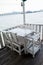White tables and chairs in restaurant. empty rattan furniture coffee set table chair at wooden floor sea front by the sea.