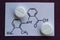 White tablets of mefenamic acid and its structural formula.