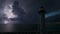 White tall lighthouse on sea shore with blinking light at stormy night for commercial vessels navigation. Thunderstorm