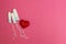 White tampons and a red heart on a pink background