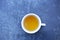 White tea cup on blue grunge mortar desk top view