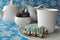 White tea set with Christmas honey cookie and chocolate walnut and date sweets on blue winter background with snowflakes