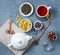 White teapot with cup of herbal tea lavender, chamomile and rose loose on blue table