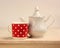 White teapot and mug red with polka dots.