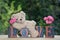 White teddy bear lies on Love stones with pink roses