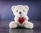 White teddy bear with love letter on red heart gray background. Say i you for valentine `s day concept.