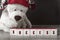 A white Teddy bear in a red hat lays out the words `Success` from the blocks .