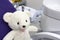 A white teddy bear sitting on an examination stool in the dental clinic