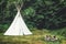 white teepee indian tent standing in beautiful landscape.