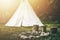 white teepee indian tent standing in beautiful landscape.