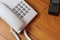 White telephone and black handy walkie talkie on wooden table