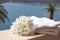White terry towel and a bouquet of flowers on background of a seascape