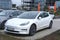white Tesla car model Y in parking, electric vehicle in European city, energy lithium-ion 4680 battery, alternative energy