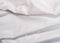 White textile, close up view. White smooth fabric, an abstract background. Cloth texture. White clean sheet, background
