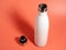 White Thermal bottle on a pink background. Thermos bottle