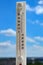 White thermometer against blue sky shows high temperature