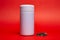 white thermos with green leaf tea on a red background