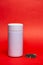 white thermos with green leaf tea on a red background