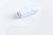 White thread and sewing needle on white background with space for text. Minimal sewing tools