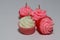 White and three pink candles in cupcake shape put on light grey background.