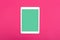 White touchpad with blank green screen on magenta background. Flat lay