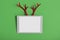 White touchpad with blank touchscreen with fake toy antlers of a deer on a red background. Merry Christmas or Happy New