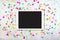 White touchpad with colorful confetti on white marble texture. Colorful confetti background with tablet computer