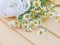 White towel and camomile bouquet on the natural wood planks
