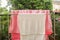 White towel and pink blanket after washing in the sun on stainless clotheshorse outside the house