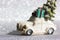 White toy truck car with green Christmas tree on roof rides on a silvered shining background. Minimalistic happy New