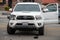 A white Toyota Tacoma truck sits in the middle of the road after an accident