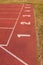 White track number on red rubber racetrack, texture of running racetracks in small outdoor stadium