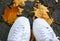 White trainers standing on autumn leaves. Hipster style photo