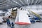 White transport airplane in the aviation hangar. Aircraft under maintenance