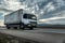 White transportation semi trailer truck on a highway at sunset